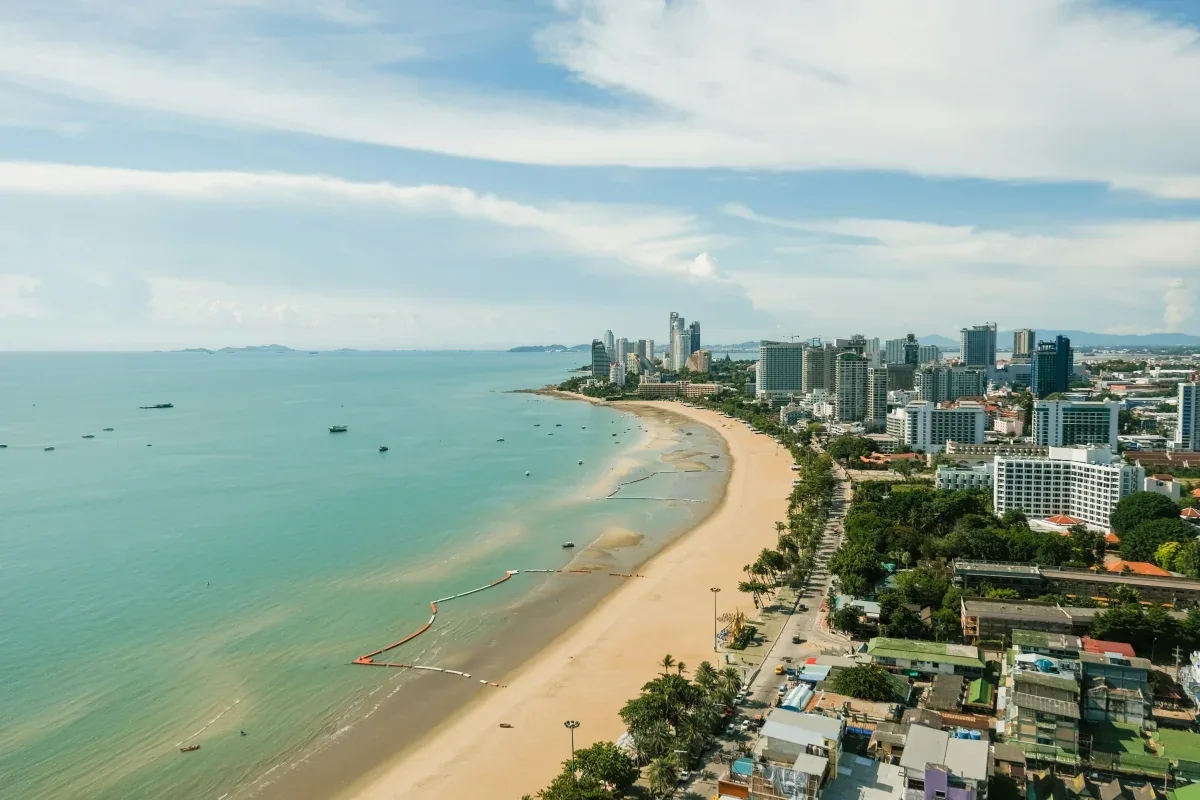 Aerial view of Pattaya Beach showing sweeping crescent bay with golden sand, high-rise hotels, and calm turquoise waters